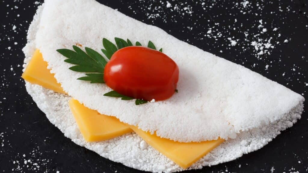 Imagem mostra uma tapioca com queijo e tomate. Ela pode ser uma opção para quem tem diabetes.