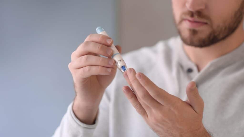 Imagem mostra pessoa fazendo exame de ponta de dedo para medir a glicose. O teste é feito diariamente por todos que convivem com diabetes.