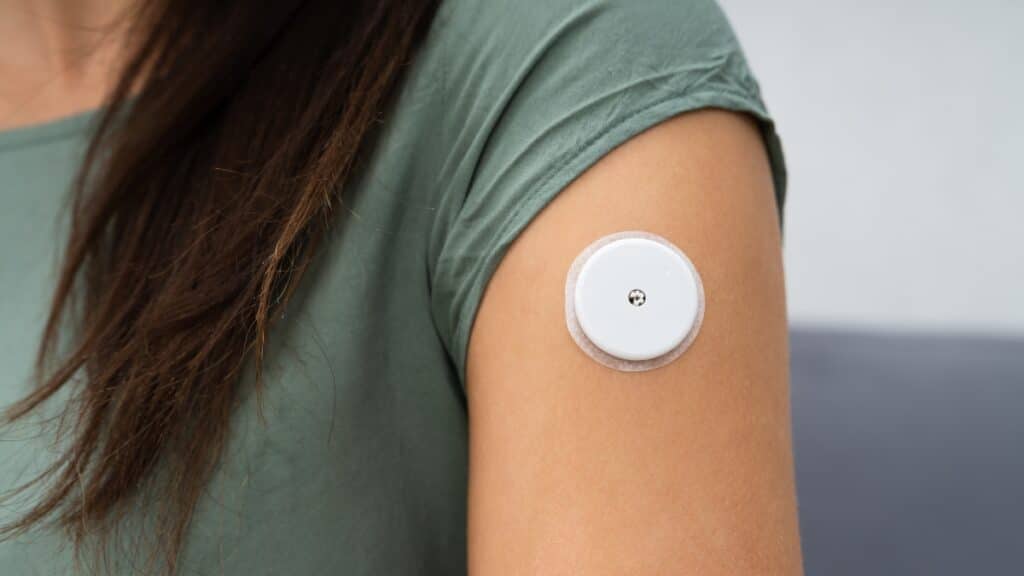 Imagem mostra uma mulher usando sensor de glicose para controlar o diabetes.