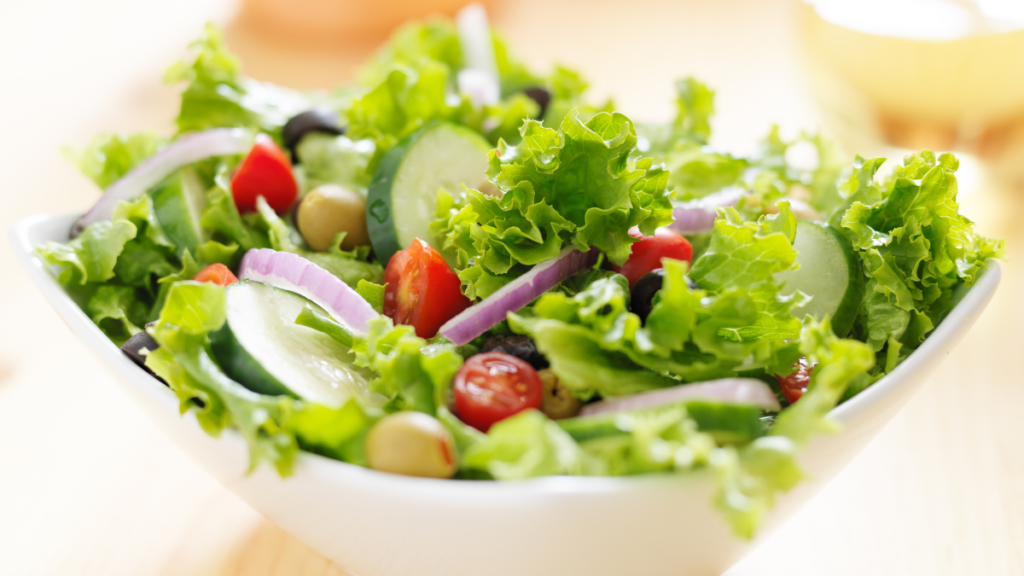 Comer salada antes do almoço pode mudar sua glicose? Entenda o que acontece Salada com alface, tomate, pepino e outros vegetais que podem ajudar no controle da glicose quando consumidos antes do almoço.