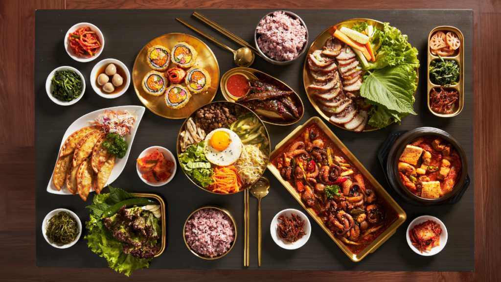 Comida coreana e diabetes: como os pratos afetam a glicose? Mesa com pratos típicos da culinária coreana, incluindo arroz, vegetais, carnes e kimchi, em matéria sobre alimentação para quem tem diabetes.